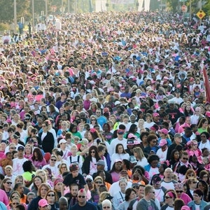A big crowd of people at the race for the cure wearing pink walking in downtown Little Rock, AR.